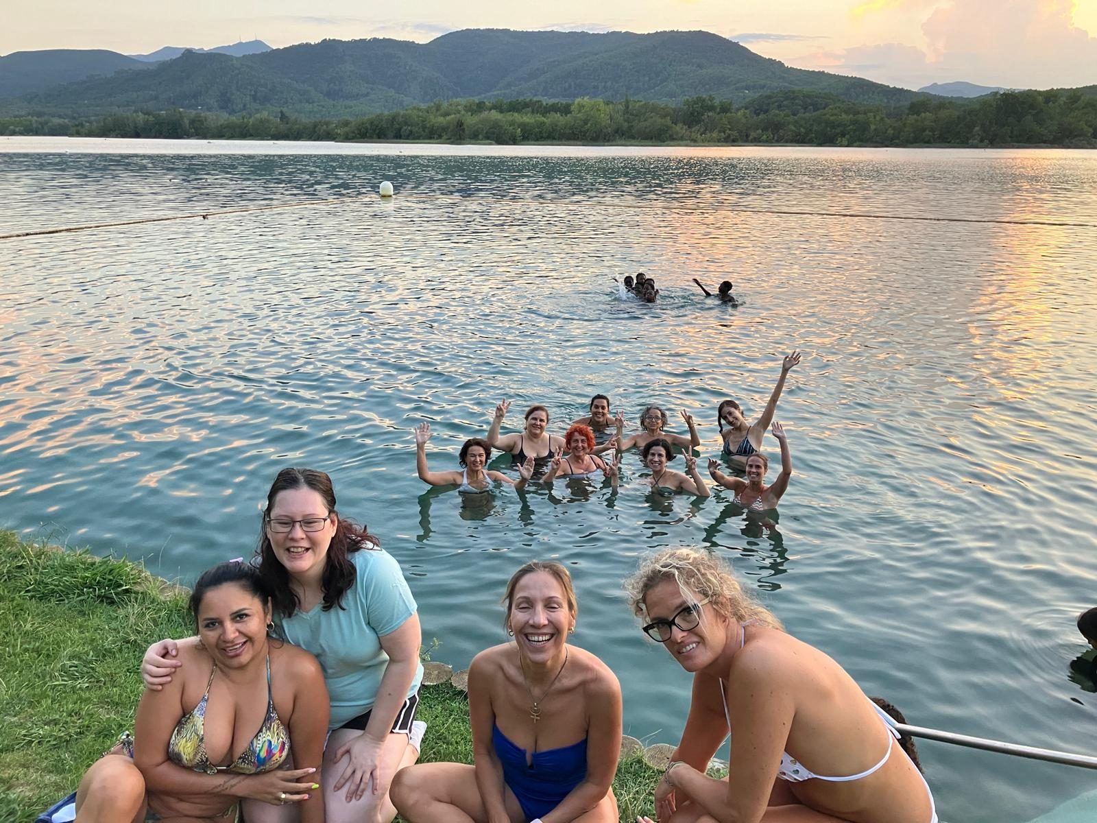 Grupo disfrutando de un lago al atardecer durante una experiencia de bienestar